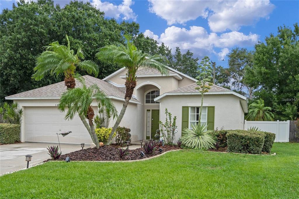 A single-story house with a two-car garage, palm trees, and a green front door — 541 HEATHER GLEN DR, WINTER HAVEN, FL