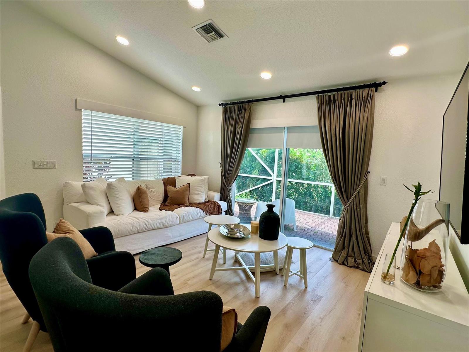 A living room features a white sofa, two dark armchairs, and sliding glass doors — 7267 Panache Way, Boca Raton FL 33433, BOCA RATON, FL