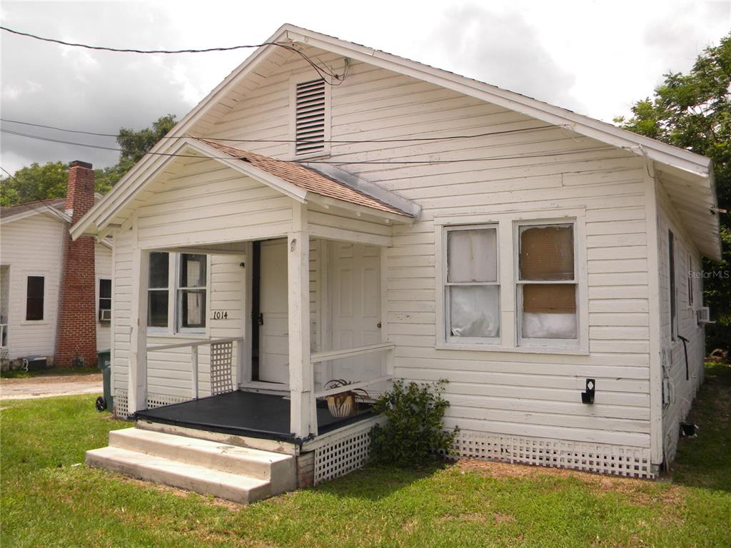 A white, single-story house with horizontal siding, a front porch, and a gabled roof — 1016 NE 8TH AVENUE, OCALA, FL