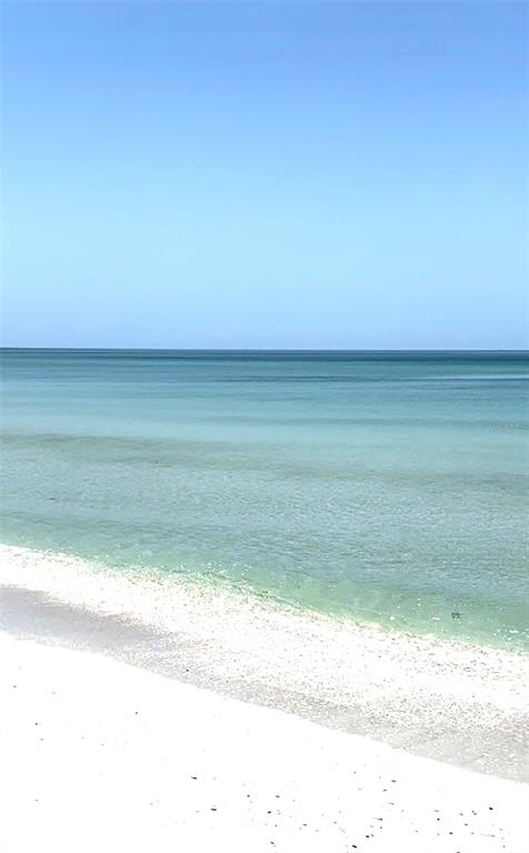 A view of a white sandy beach meeting the calm, clear turquoise ocean water — 4377 DURANT STREET, PORT CHARLOTTE, FL