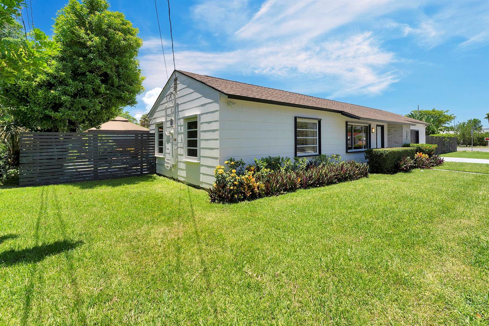 A white single-story house with a brown roof sits on a green lawn — 2301 Ridgeway Avenue, West Palm Beach FL 33401, WEST PALM BEACH, FL