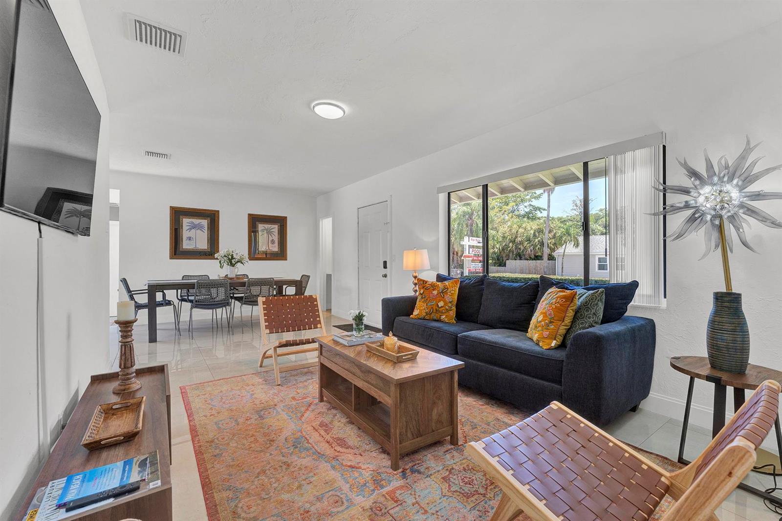 A living room features a dark blue sofa, a wooden coffee table, and a dining area — 2301 Ridgeway Avenue, West Palm Beach FL 33401, WEST PALM BEACH, FL