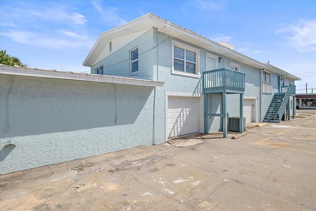 A light blue two-story building with a garage, an exterior staircase, and a balcony — 236 GROVE STREET S, VENICE, FL