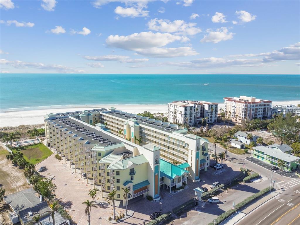 An aerial view of a multi-story beachfront resort with a parking lot and ocean — 12000 GULF BOULEVARD UNIT 304S, TREASURE ISLAND, FL