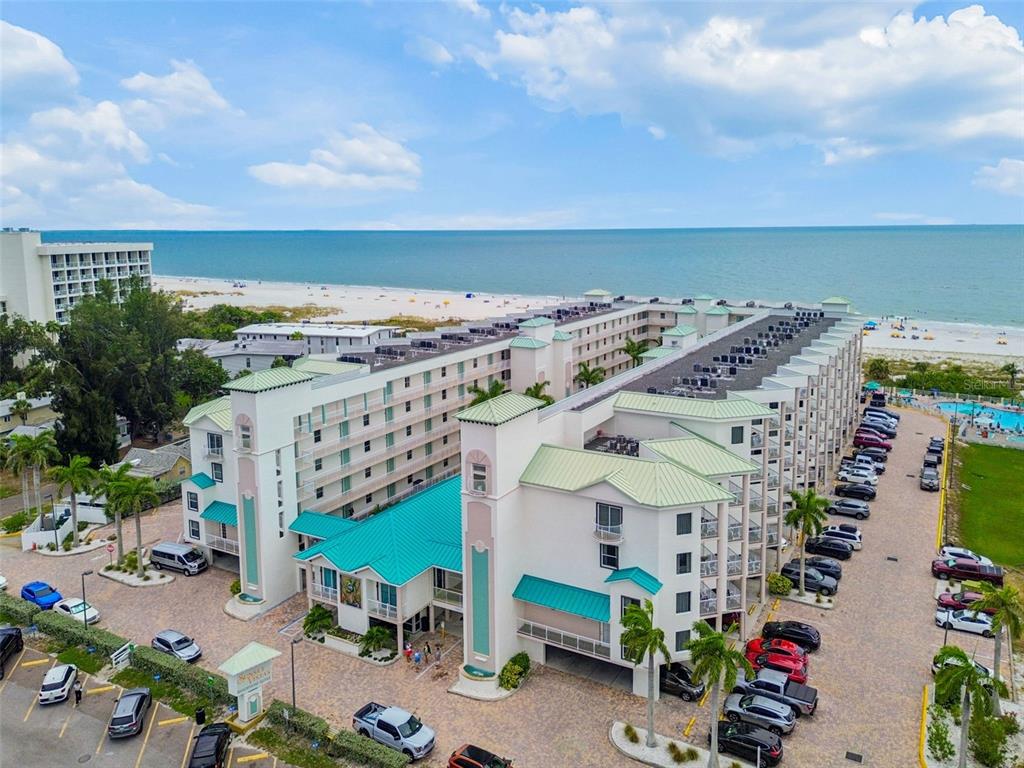 An aerial view of a multi-story beachside resort with a parking lot and oceanfront access — 12000 GULF BOULEVARD UNIT 304S, TREASURE ISLAND, FL
