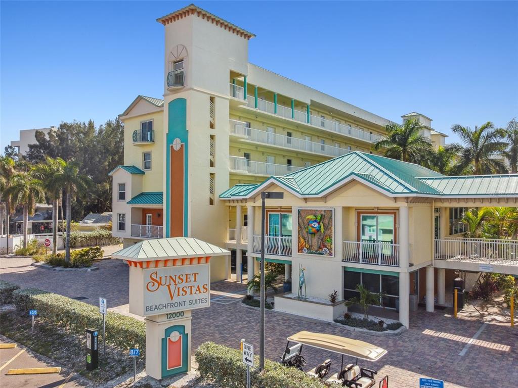 The exterior of a multi-story hotel building features a prominent sign and a golf cart — 12000 GULF BOULEVARD UNIT 304S, TREASURE ISLAND, FL