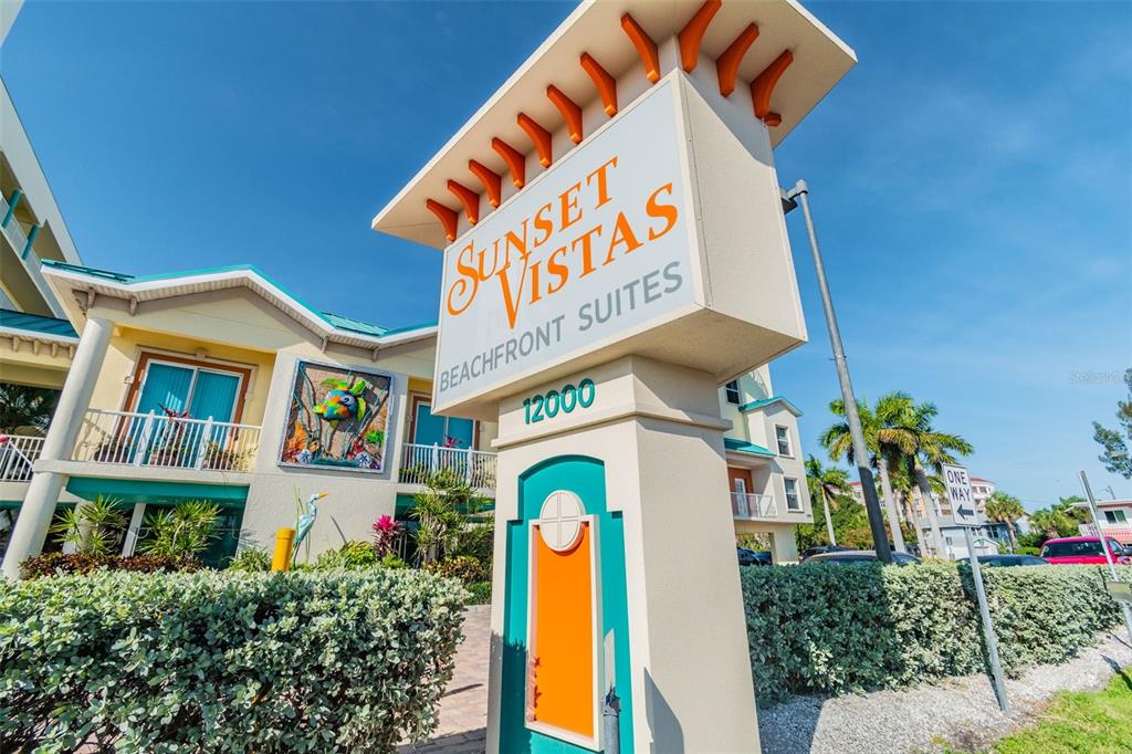 A sign for Sunset Vistas Beachfront Suites stands in front of a multi-story resort building — 12000 GULF BOULEVARD UNIT 304S, TREASURE ISLAND, FL