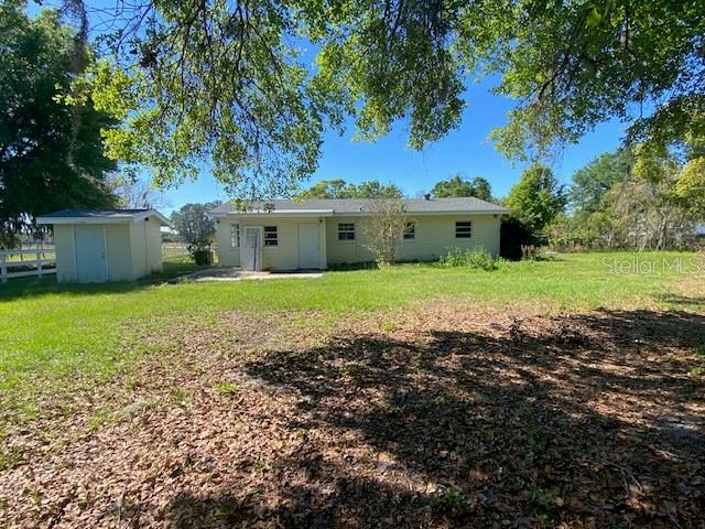 A single-story house with a detached shed sits on a grassy lot under large trees — 4316 E KNIGHTS GRIFFIN ROAD, PLANT CITY, FL