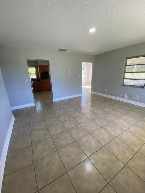 A room with light gray walls, beige tile flooring, and two doorways leading to other areas — 4316 E KNIGHTS GRIFFIN ROAD, PLANT CITY, FL