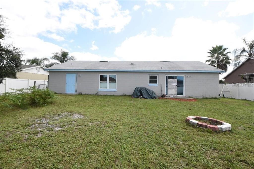 The exterior of a gray single-story house features a light blue door and sliding doors — 2924 GIMLET DRIVE, DELTONA, FL
