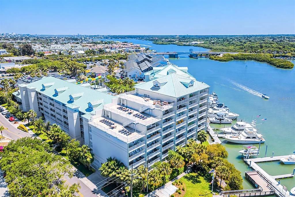 A blue sign for Harbourside at Marker 33 stands behind green bushes and palm trees — 399 2ND STREET UNIT 416, INDIAN ROCKS BEACH, FL