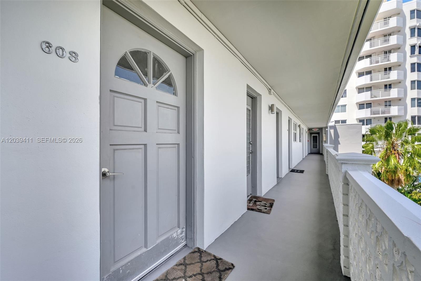 An exterior hallway features a gray door labeled 603 and a view of a neighboring building — 1620 West Ave # 603, Miami Beach FL 33139, MIAMI BEACH, FL