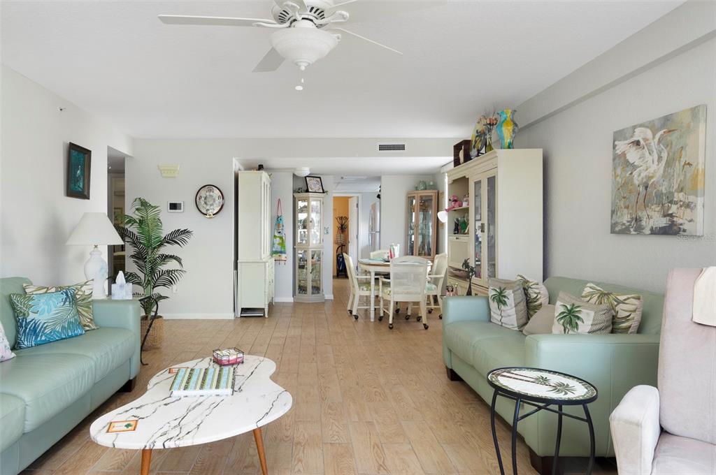 A living room with light green sofas, a marble coffee table, and a dining area — 1950 59TH AVENUE N UNIT 119, ST PETERSBURG, FL