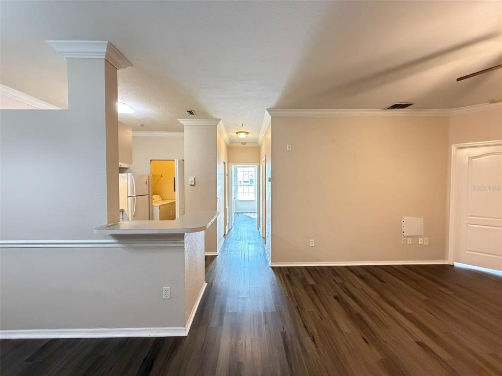 A view from a living area looking toward a kitchen and a hallway with flooring — 3319 S KIRKMAN ROAD UNIT 311, ORLANDO, FL