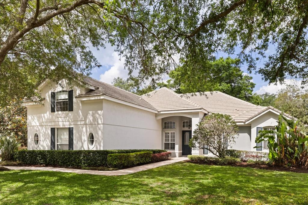 A two-story white stucco house with a tiled roof and a landscaped front yard — 987 BRIGHTWATER CIRCLE, MAITLAND, FL