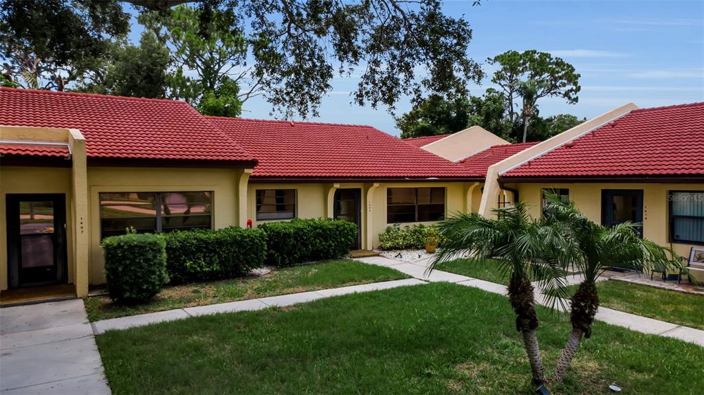 A single-story building with a red tile roof and a small front lawn — 1409 56TH STREET W UNIT 1409, BRADENTON, FL