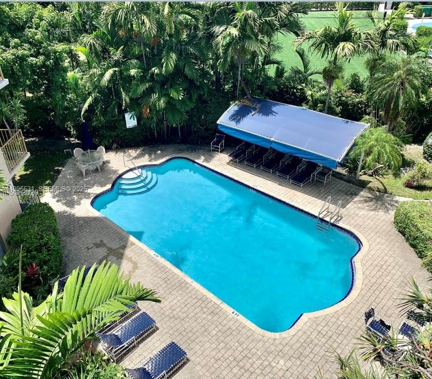 An aerial view of a swimming pool surrounded by a paved deck and lush landscaping — BAY HARBOR ISLANDS, FL