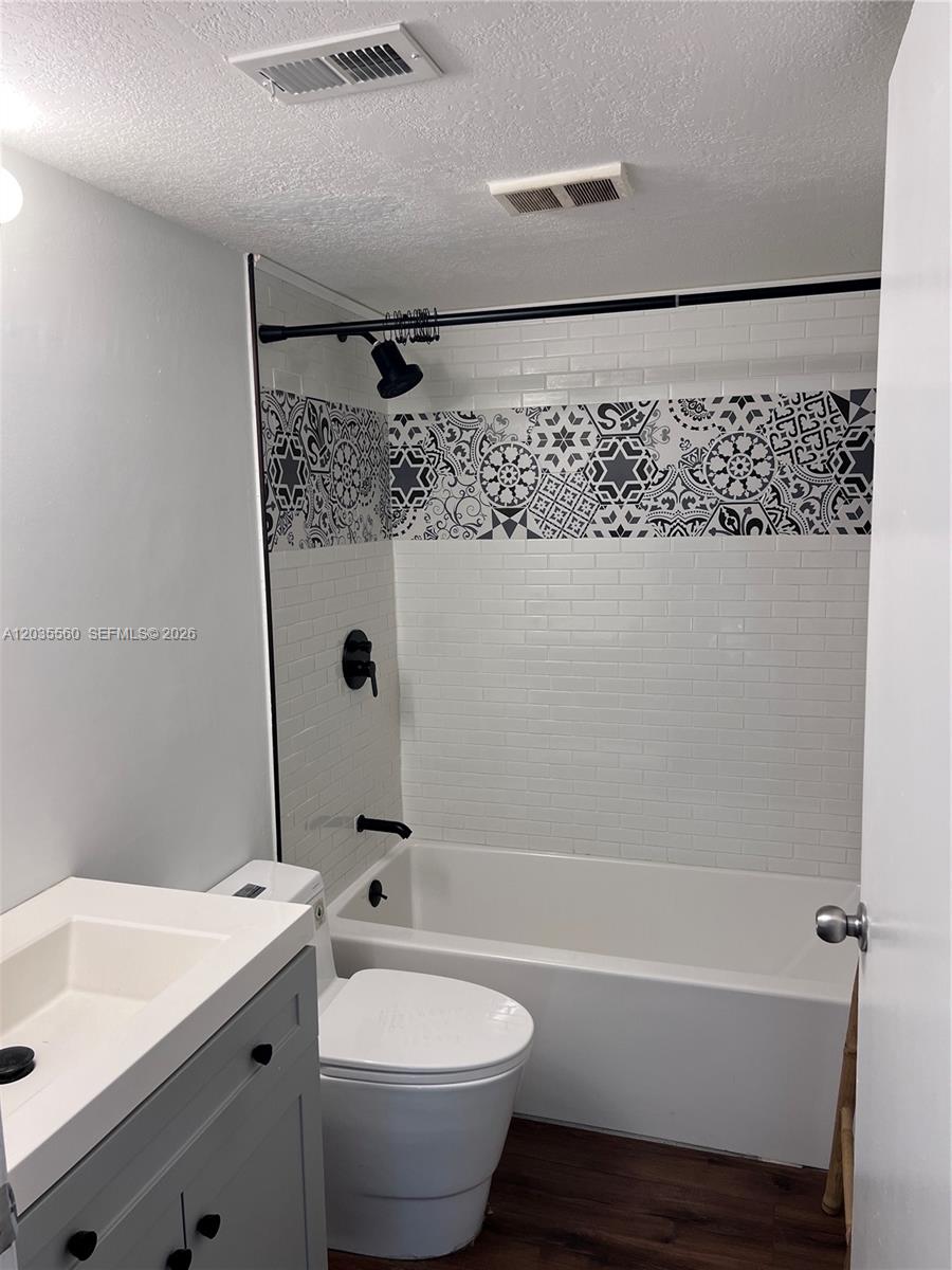 A bathroom features a white subway tile shower surround with a patterned accent tile border — HOLLYWOOD, FL