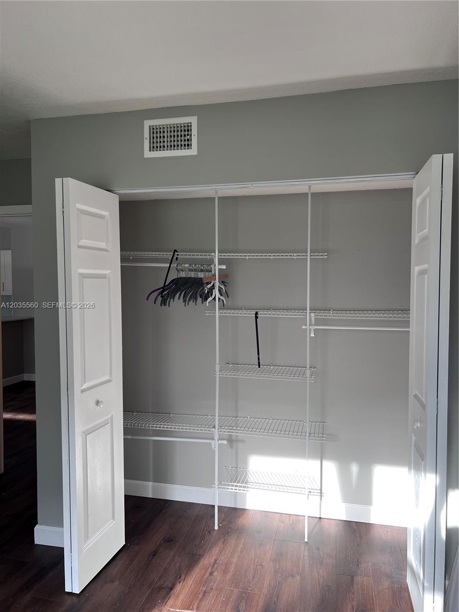 A closet with white wire shelving and bi-fold doors sits against a gray wall — HOLLYWOOD, FL