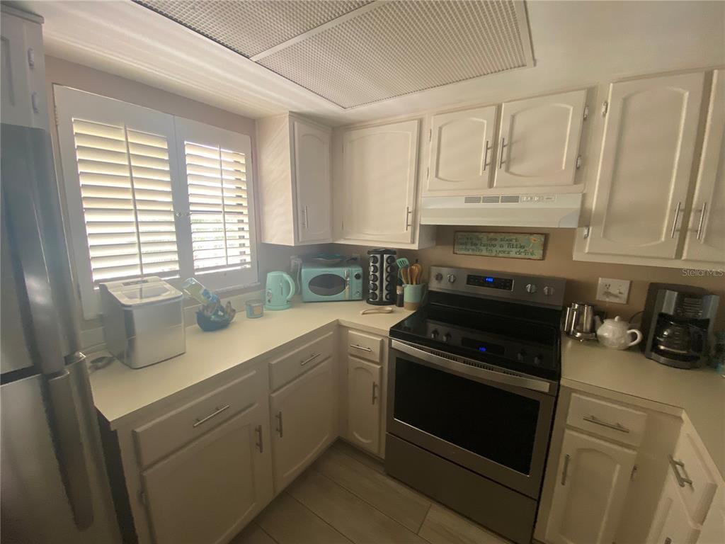 A kitchen features white cabinets, stainless steel appliances, and light-colored countertops — 4175 S ATLANTIC AVENUE UNIT 3160, NEW SMYRNA BEACH, FL