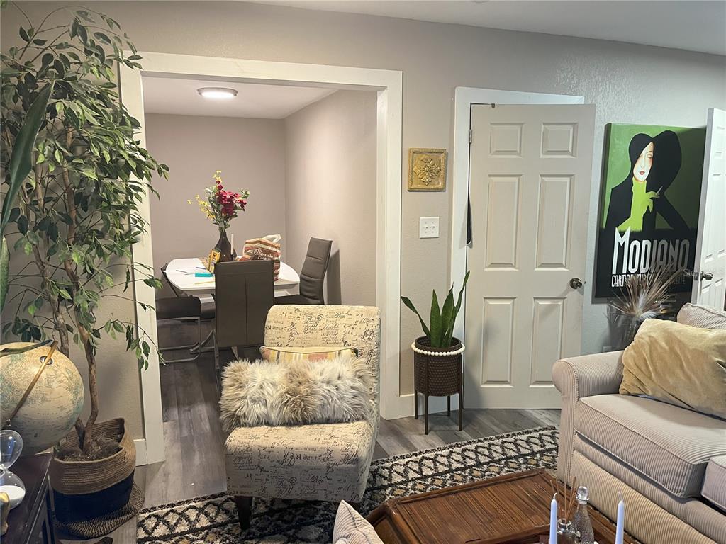 A living room with a patterned armchair leads into a dining area with a table — 1874 DOUGLAS AVENUE, CLEARWATER, FL