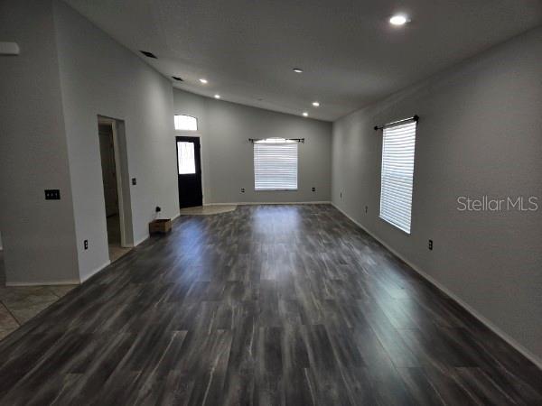 An empty living room features gray walls, recessed lighting, and dark wood-look flooring — 2235 LAKERIDGE DRIVE, WINTER HAVEN, FL