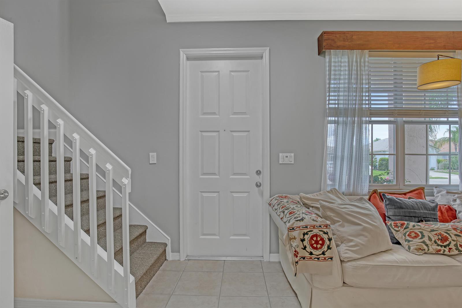 A carpeted staircase sits beside a white front door in a room with gray walls — 10751 Oak Bend Way, Wellington FL 33414, WELLINGTON, FL