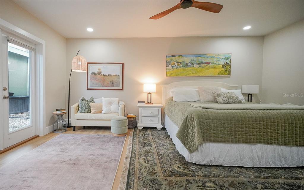 A bedroom features a king bed, a small sofa, a rug, and a glass door — 3207 W NASSAU STREET, TAMPA, FL