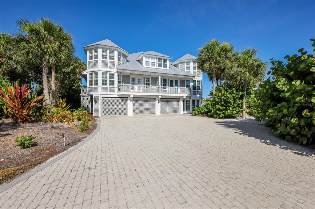 A three-story house with a three-car garage and a paved driveway surrounded by palm trees — 17 SEAWATCH DRIVE, BOCA GRANDE, FL