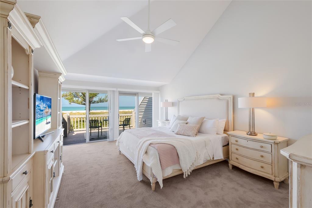 A bedroom with a vaulted ceiling, king bed, and sliding glass doors overlooking the beach — 17 SEAWATCH DRIVE, BOCA GRANDE, FL