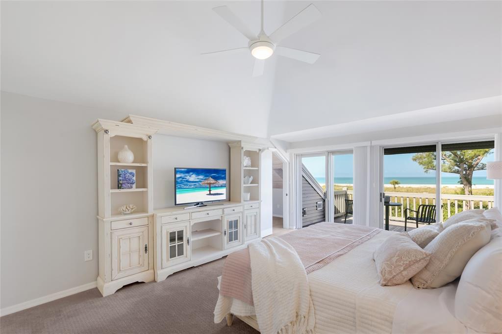A bedroom features a white entertainment center, a ceiling fan, and sliding doors overlooking the ocean — 17 SEAWATCH DRIVE, BOCA GRANDE, FL