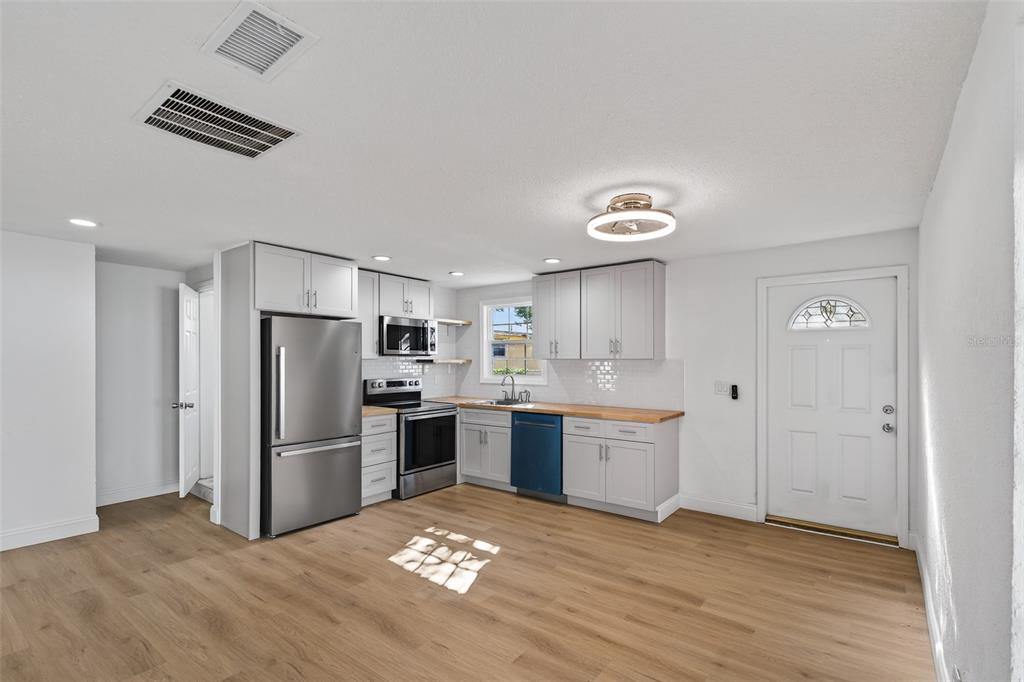 A kitchen with light gray cabinets, stainless steel appliances, and wood-look flooring — 4545 12TH AVENUE S, ST PETERSBURG, FL