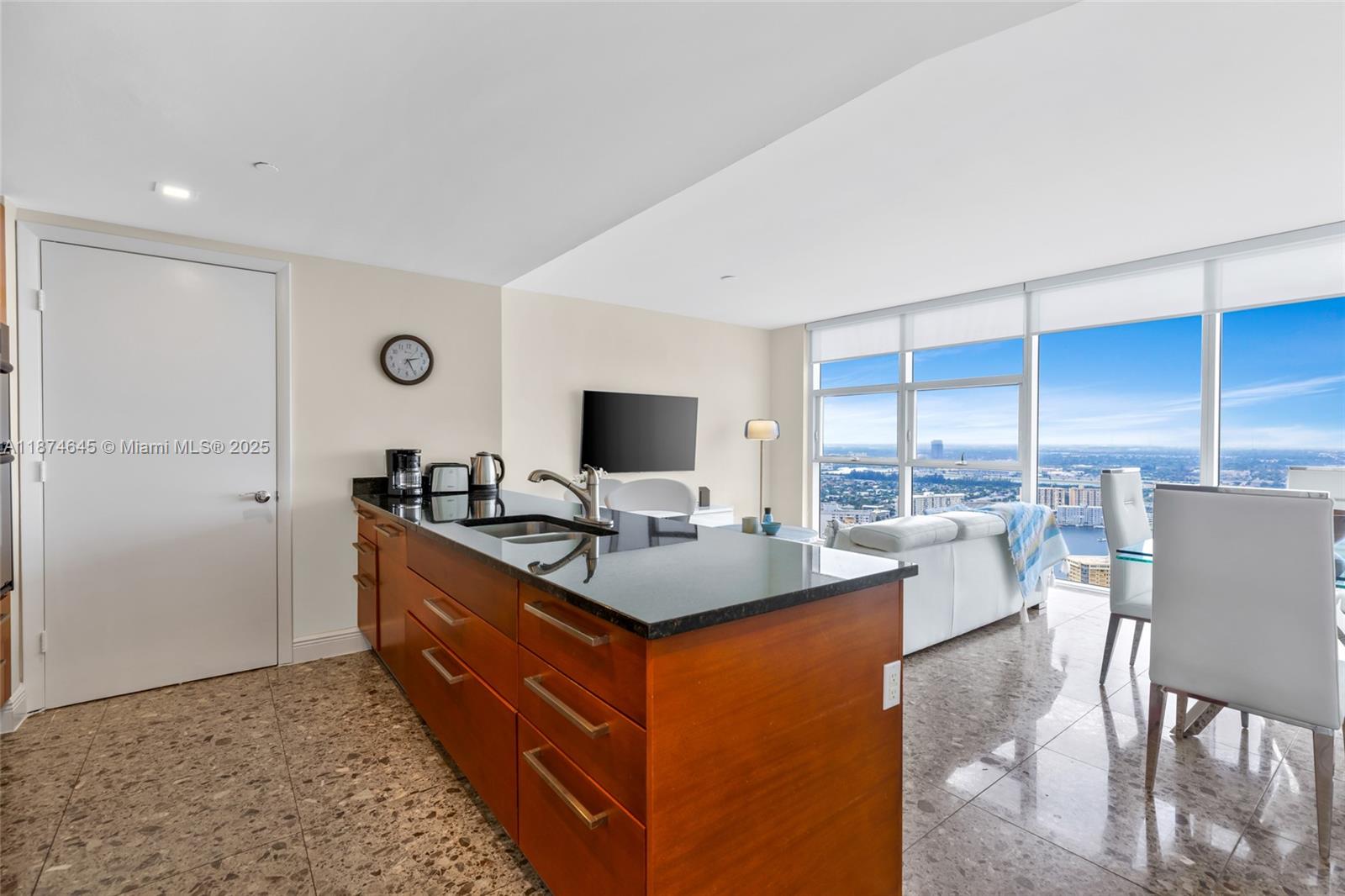 A kitchen island with dark countertops sits in an open-plan room with floor-to-ceiling windows — 1830 S Ocean Dr # 4107, Hallandale Beach FL 33009, HALLANDALE BEACH, FL