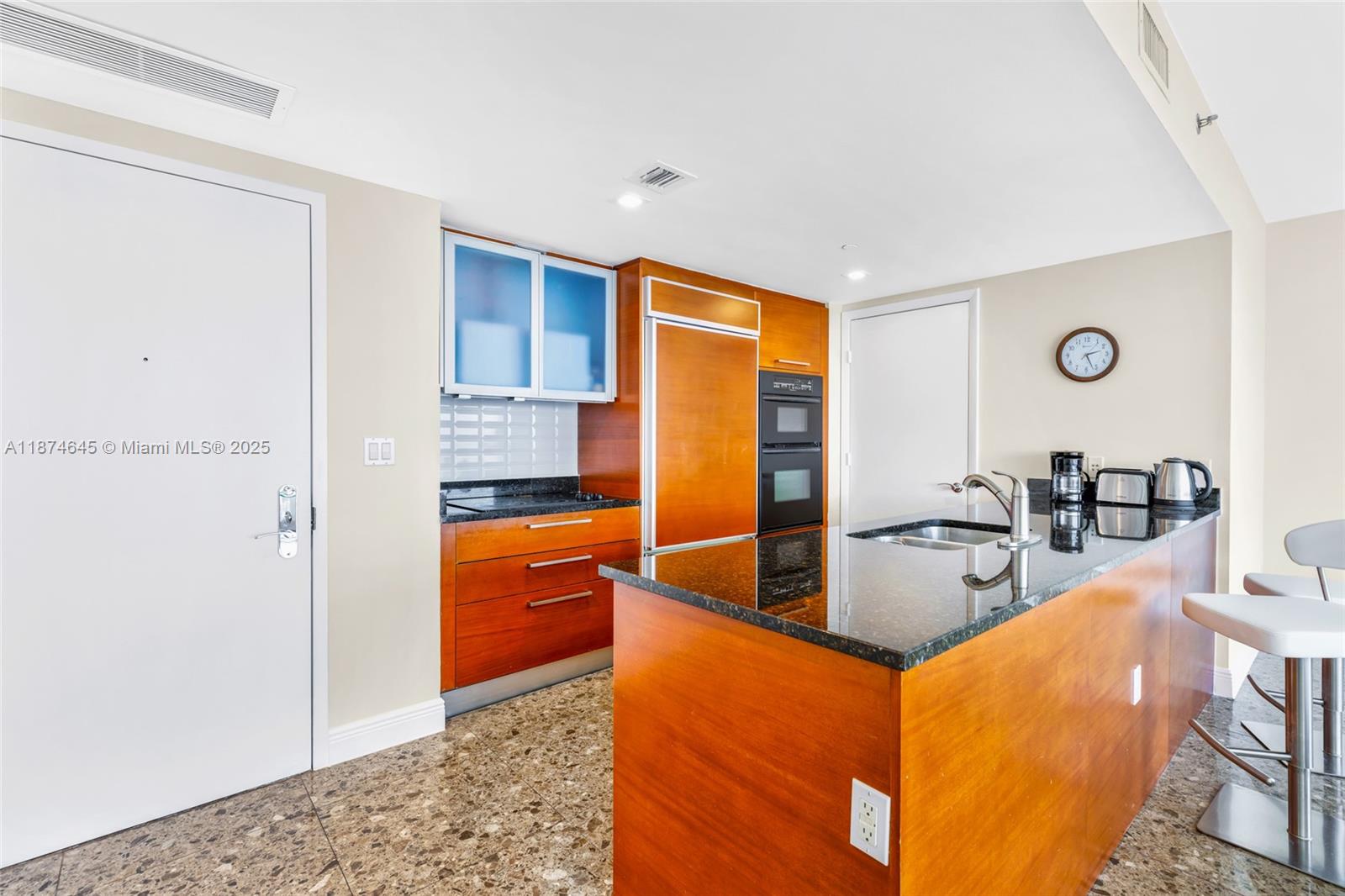 A kitchen features wood cabinetry, dark granite countertops, stainless steel appliances, and a breakfast bar — 1830 S Ocean Dr # 4107, Hallandale Beach FL 33009, HALLANDALE BEACH, FL