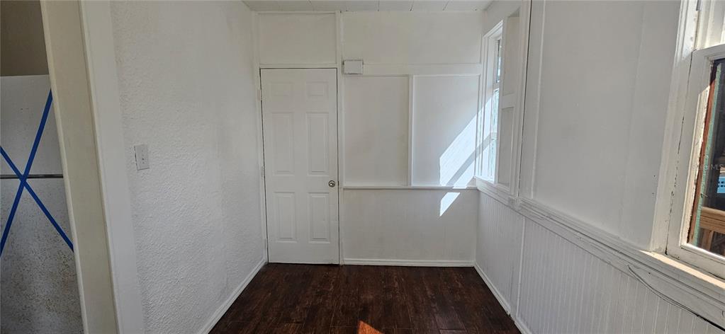 A small room with white walls, a white door, and dark wood-look flooring — 709 ORA STREET UNIT 06, DAYTONA BEACH, FL