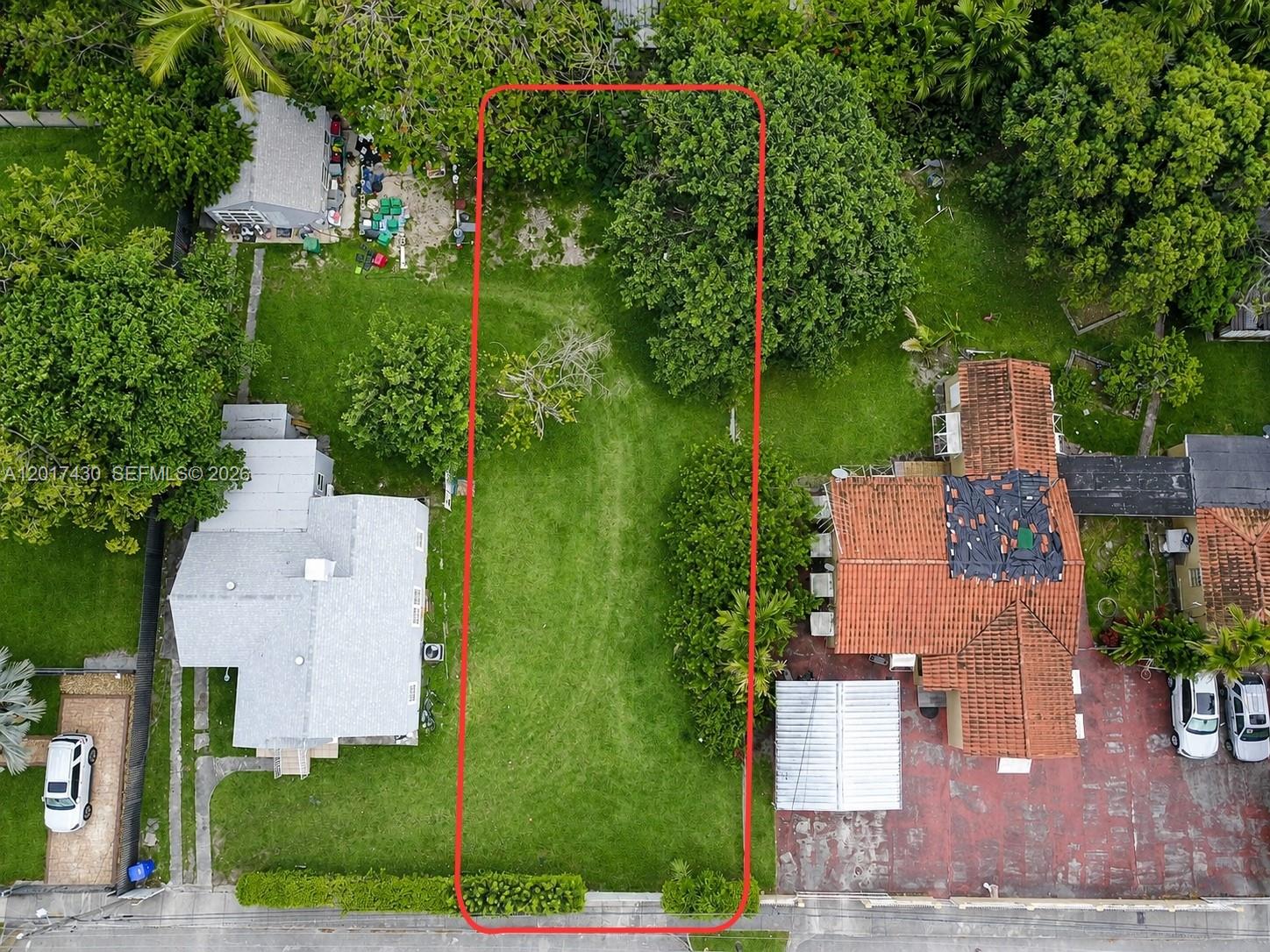 An aerial view shows a rectangular vacant lot outlined in red between two residential properties — 26 St 1555 NW 26 St, Miami FL 33142, MIAMI, FL