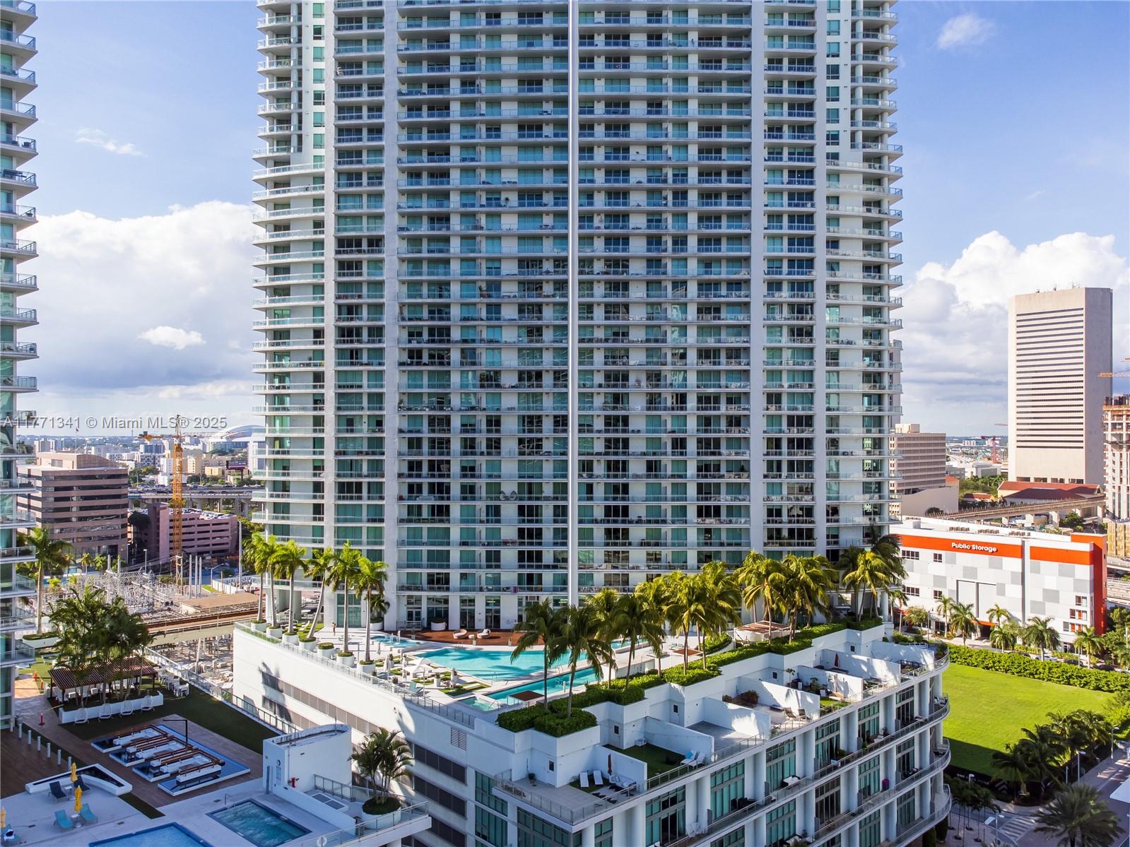 An exterior view of a high-rise residential building featuring a pool deck with palm trees — 90 SW 3rd St # 4103, Miami FL 33130, MIAMI, FL