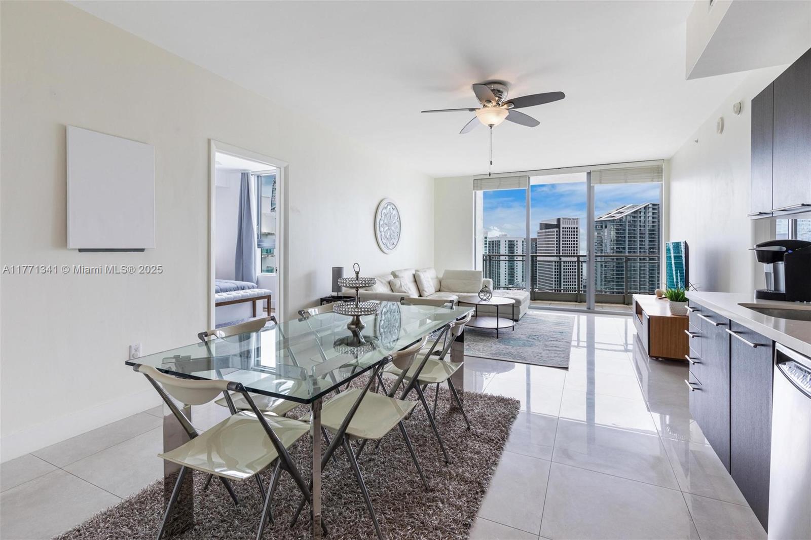A modern living and dining area features tile floors, a glass table, and balcony views — 90 SW 3rd St # 4103, Miami FL 33130, MIAMI, FL