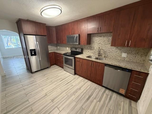A kitchen features wood cabinets, stainless steel appliances, granite countertops, and light-colored tile flooring — 2742 SW 32nd Ave # 2742, Miami FL 33133, MIAMI, FL