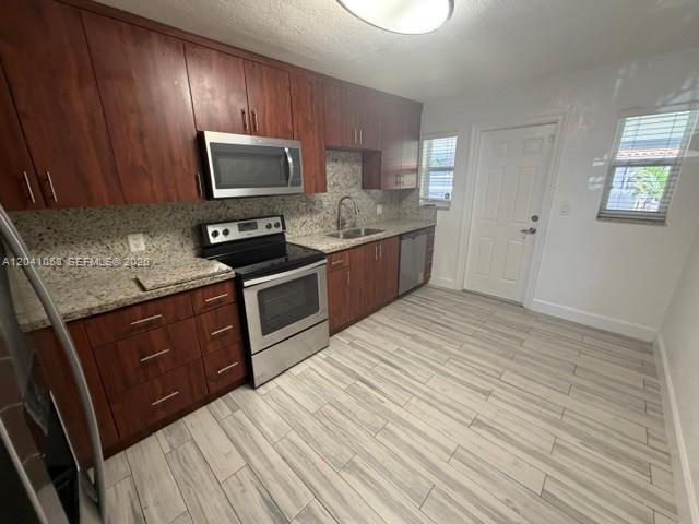 A kitchen features wood cabinets, stainless steel appliances, granite countertops, and light-colored tile flooring — 2742 SW 32nd Ave # 2742, Miami FL 33133, MIAMI, FL
