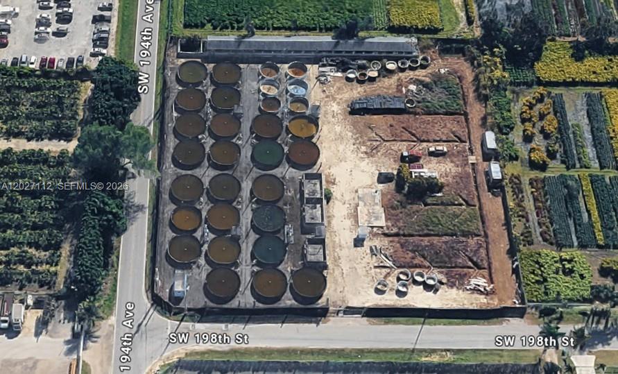 An aerial view shows a fenced industrial lot containing numerous circular tanks and open land — 19490 SW 198TH ST, Miami FL 33187, MIAMI, FL