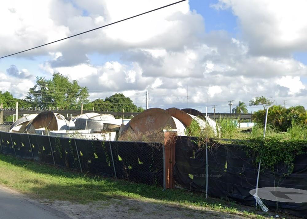 A chain-link fence encloses a lot containing several large, weathered, dome-shaped metal structures — 19490 SW 198TH ST, Miami FL 33187, MIAMI, FL
