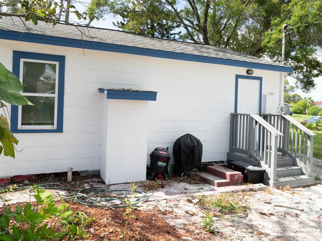 The exterior of a white house with blue trim, a small porch, and a yard — 3227 5TH AVE S, ST PETERSBURG, FL