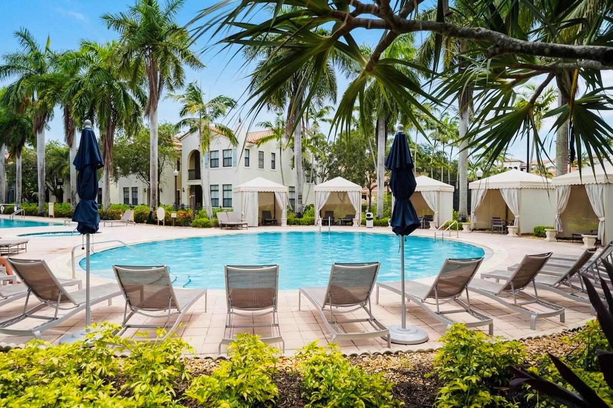 A swimming pool surrounded by lounge chairs, cabanas, palm trees, and a multi-story building — 3162 NW 124th Way, Sunrise FL 33323, SUNRISE, FL