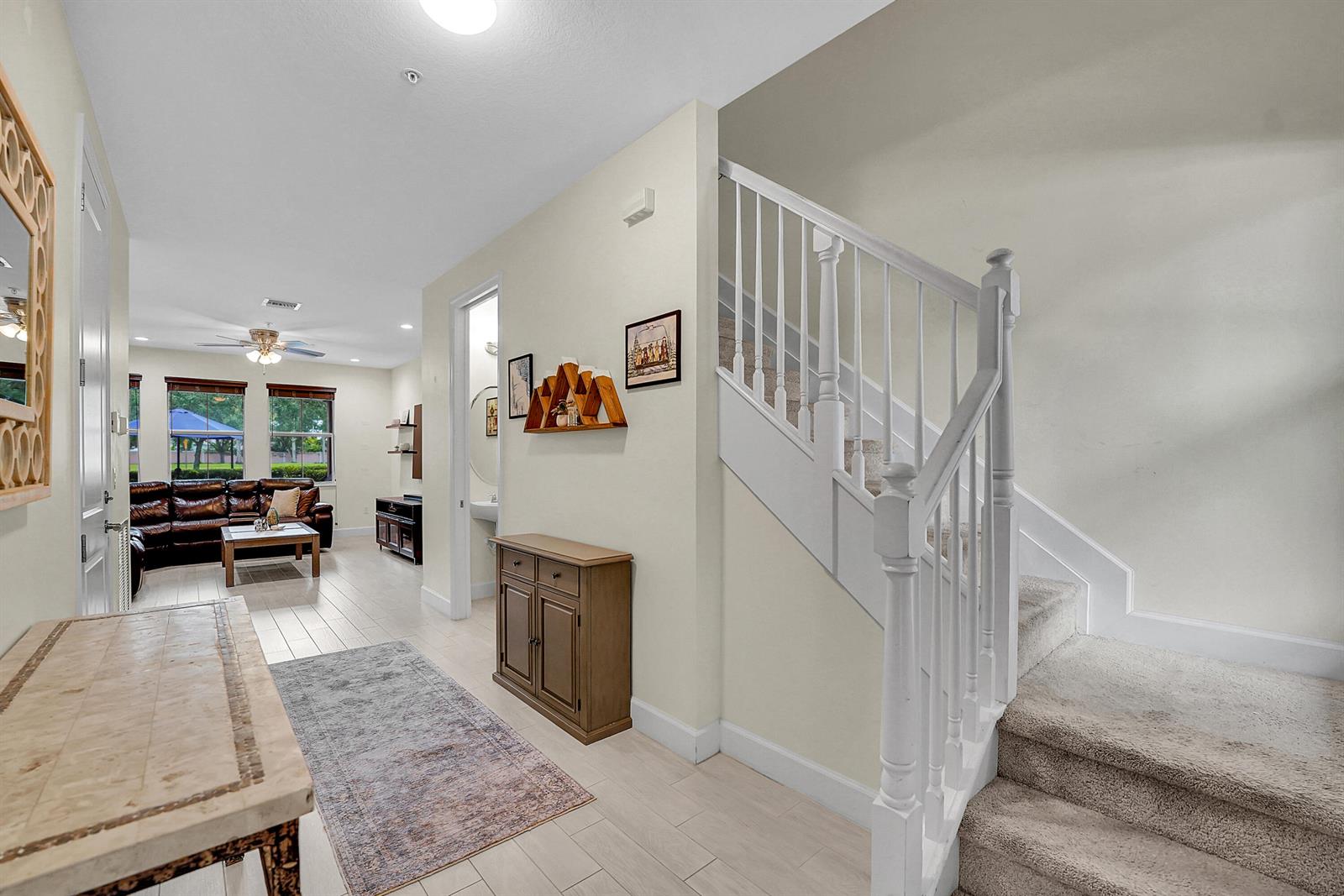 An entryway features a staircase, a wooden cabinet, and a view into the living room — 3162 NW 124th Way, Sunrise FL 33323, SUNRISE, FL