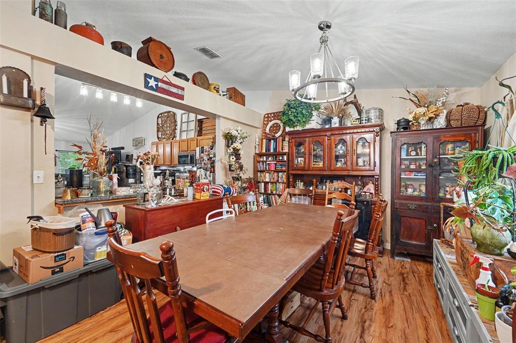 A dining room features a wooden table, chairs, hutch, and an open view into the kitchen — 1210 W FAN DRIVE, CITRUS SPRINGS, FL