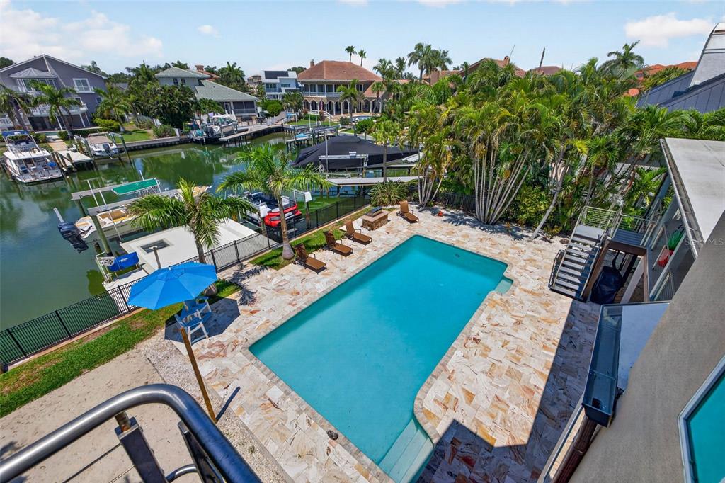 An elevated view of a backyard swimming pool, stone patio, and private boat dock — 113 7TH STREET E, ST PETERSBURG, FL