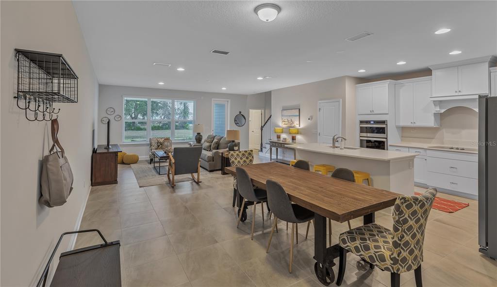 An open-concept living and dining area features tile flooring, a kitchen island, and white cabinetry — 7511 SEA OAK COURT, PARRISH, FL