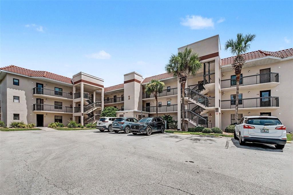 A multi-story apartment building with a parking lot in the foreground under a blue sky — 4250 A1A S UNIT I-16, ST AUGUSTINE, FL