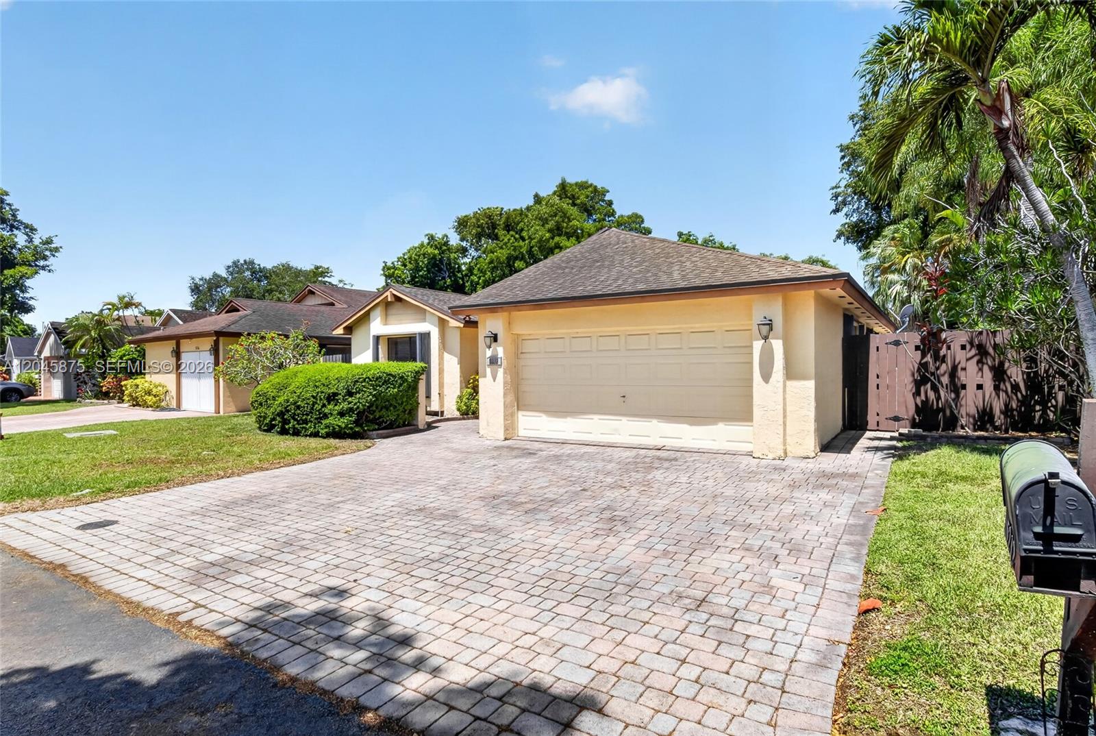 A single-story house with a beige stucco exterior, a paved driveway, and a two-car garage — 5212 SW 151st Pl, Miami FL 33185, MIAMI, FL